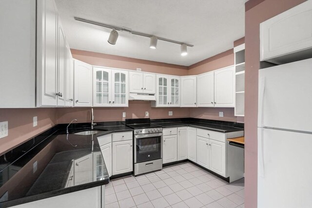 kitchen with a sink, white cabinets, under cabinet range hood, appliances with stainless steel finishes, and light tile patterned flooring