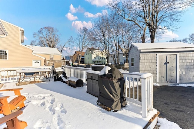 snowy yard featuring a shed