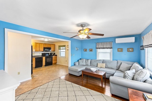 living room featuring light tile patterned flooring, an AC wall unit, and ceiling fan