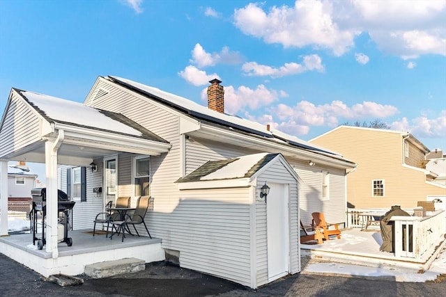 back of house featuring solar panels