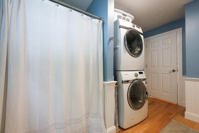 43 Thompson St, Maynard, MA 01754 - washroom featuring stacked washer / dryer, light wood finished floors, and a wainscoted wall