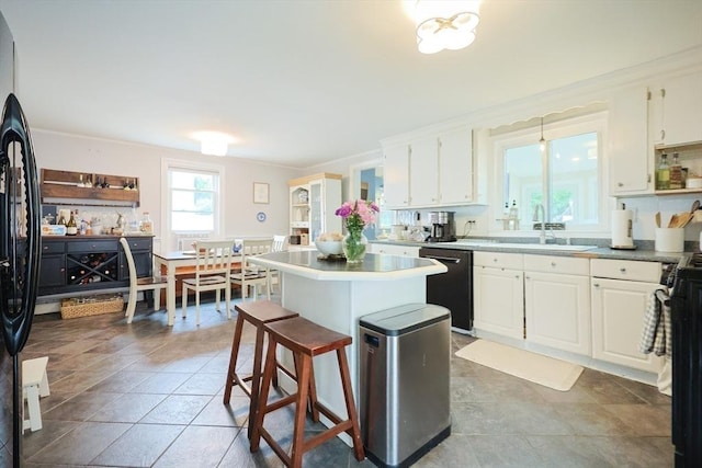 43 Thompson St, Maynard, MA 01754 - kitchen with dishwashing machine, white cabinetry, crown molding, freestanding refrigerator, and a center island