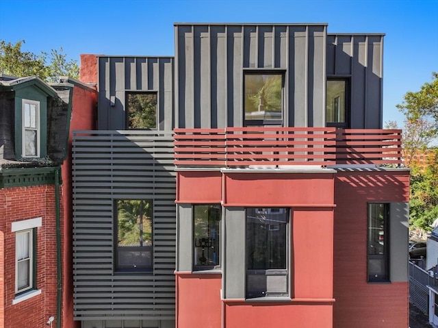 exterior space with board and batten siding and a balcony