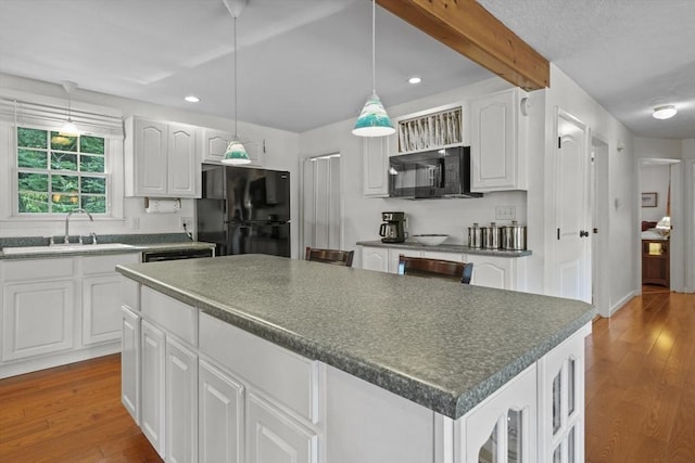 132 Biscayne St, Leominster, MA 01453 - kitchen with black appliances, dark countertops, wood finished floors, recessed lighting, and a center island