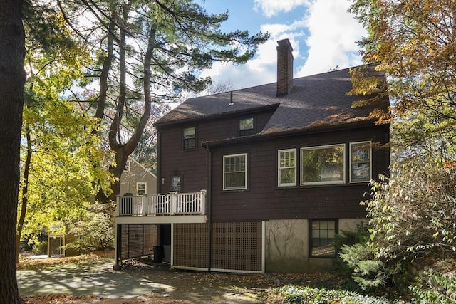 back of house featuring a chimney and a deck