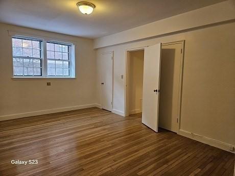 unfurnished bedroom with dark hardwood / wood-style flooring