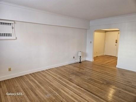 empty room featuring crown molding and hardwood / wood-style flooring