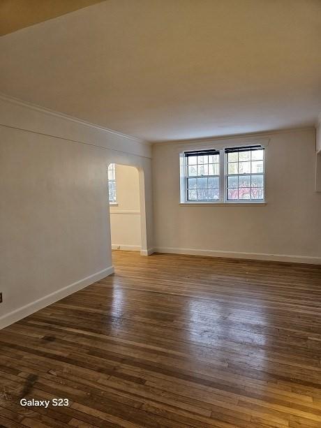 unfurnished room with dark wood-type flooring and ornamental molding