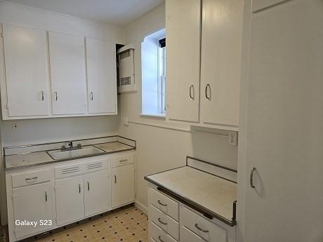 kitchen featuring white cabinetry and sink