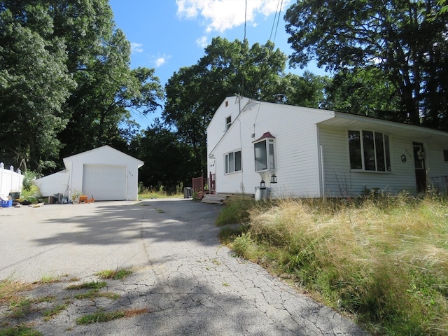 view of property exterior with an outdoor structure and a garage