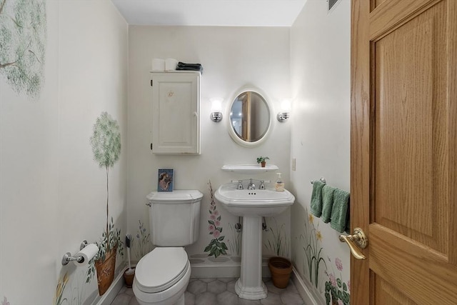 bathroom featuring toilet, baseboards, and tile patterned floors