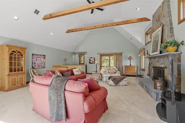 living area featuring visible vents, beamed ceiling, a stone fireplace, high vaulted ceiling, and light colored carpet