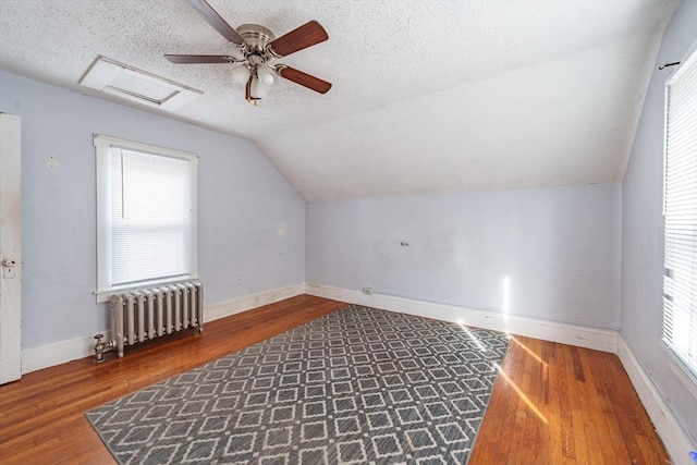 bonus room featuring radiator, a textured ceiling, and hardwood / wood-style floors