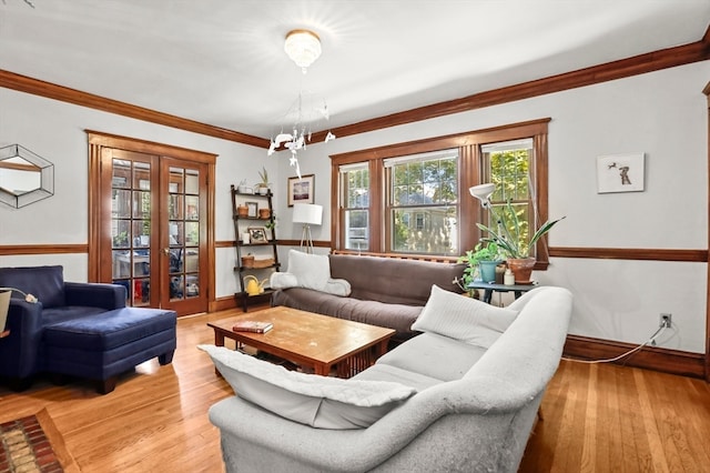 living room with light hardwood / wood-style flooring, a chandelier, and crown molding