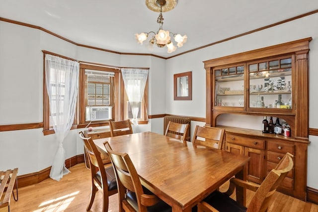 dining room featuring crown molding, cooling unit, light hardwood / wood-style flooring, and a notable chandelier