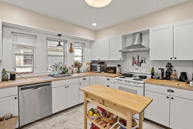 kitchen with wall chimney exhaust hood, stainless steel appliances, white cabinetry, and pendant lighting