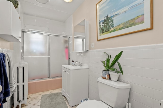 full bathroom with enclosed tub / shower combo, vanity, toilet, tile walls, and tile patterned flooring