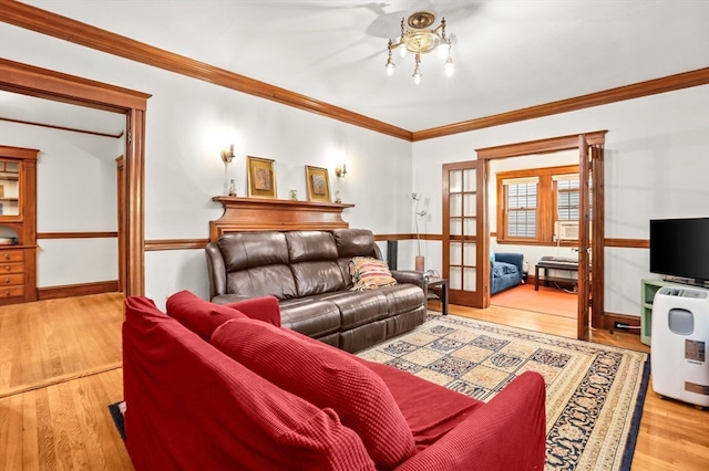 living room featuring french doors, crown molding, and light hardwood / wood-style floors