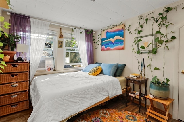 bedroom with cooling unit and dark hardwood / wood-style floors