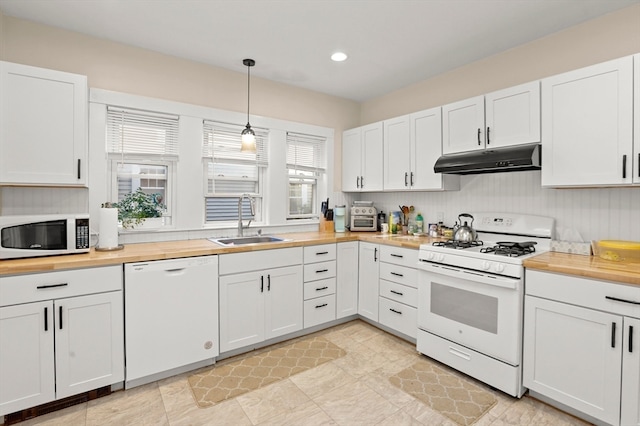 kitchen featuring white appliances, sink, pendant lighting, and white cabinets