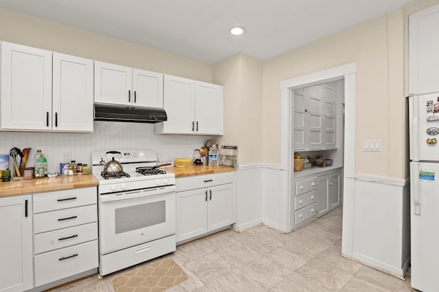 kitchen with white cabinets, white appliances, and butcher block countertops