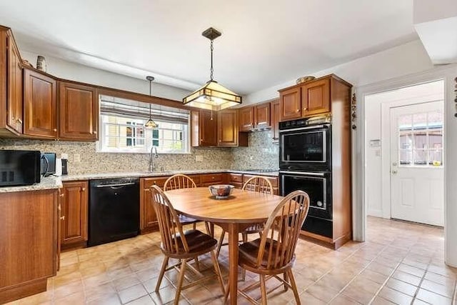 kitchen featuring decorative backsplash, pendant lighting, a sink, light tile patterned floors, and black appliances