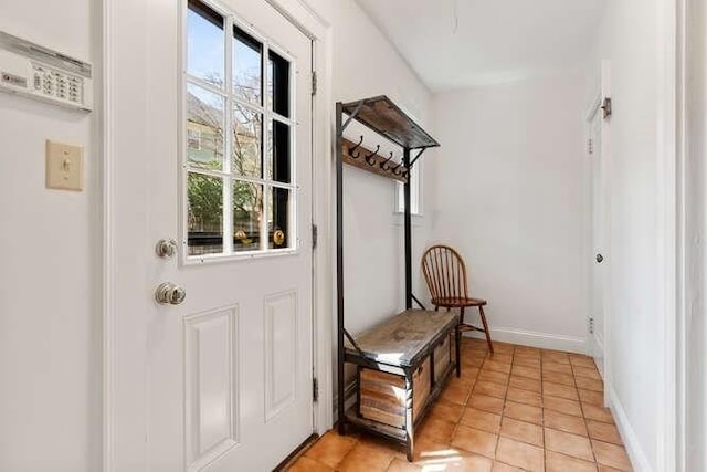 doorway featuring baseboards and light tile patterned floors