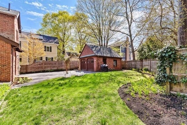 view of yard featuring a patio, an outbuilding, and a fenced backyard