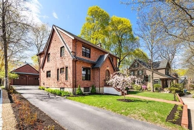 view of side of property featuring a garage, a yard, and brick siding