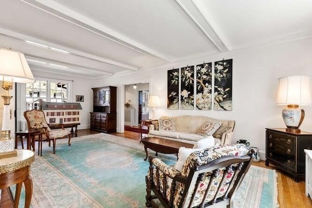living room with baseboards, beam ceiling, and wood finished floors