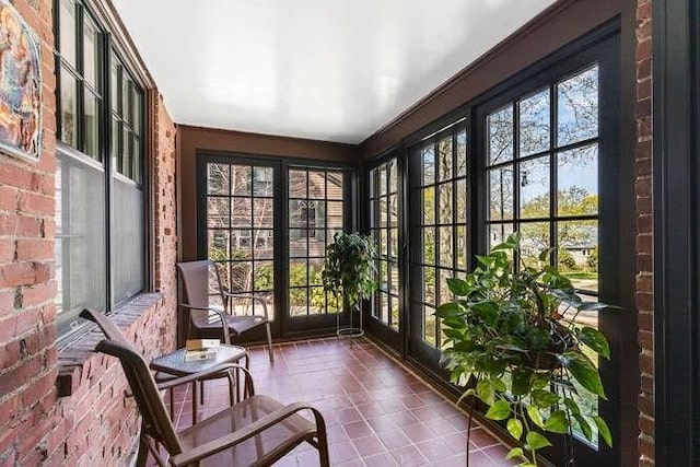 sunroom / solarium featuring brick wall