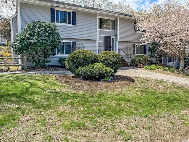 split foyer home with a front lawn