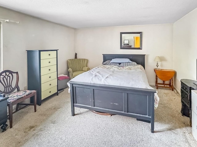 bedroom featuring a textured ceiling and light colored carpet