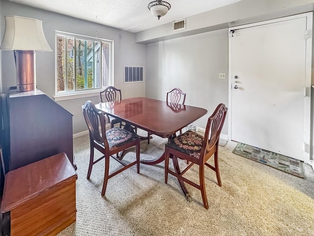 dining space featuring visible vents, carpet flooring, baseboards, and a textured ceiling