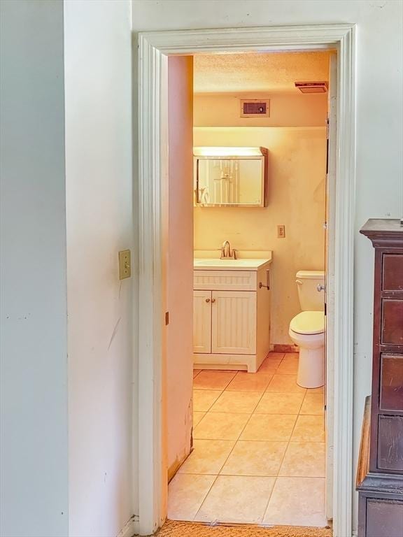 bathroom featuring vanity, tile patterned flooring, toilet, and visible vents