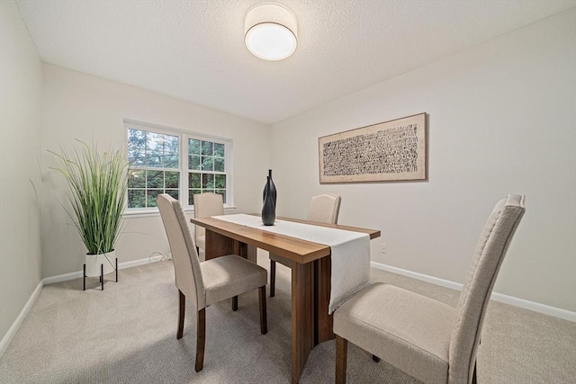 carpeted dining area with baseboards and a textured ceiling