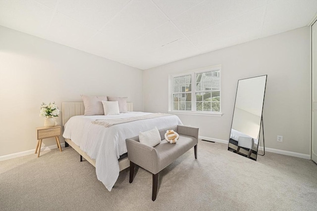bedroom featuring light carpet and baseboards