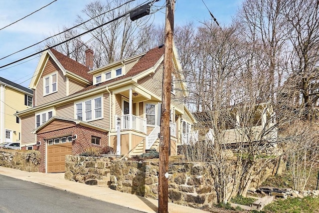 view of front of property featuring brick siding, stairway, and a garage