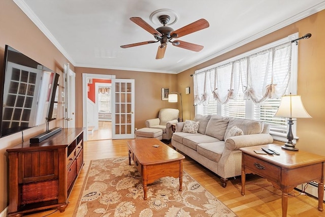 living room with a healthy amount of sunlight, light wood-style flooring, and ornamental molding