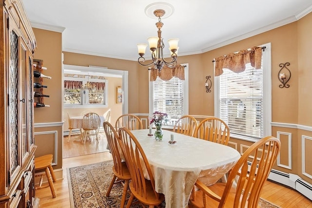 dining space featuring a wainscoted wall, a notable chandelier, light wood-type flooring, and ornamental molding