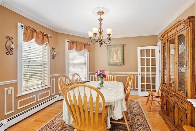 dining room with light wood-style floors, baseboard heating, an inviting chandelier, and crown molding