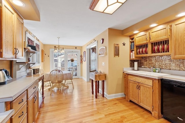 kitchen with a sink, backsplash, black dishwasher, light wood-style flooring, and open shelves