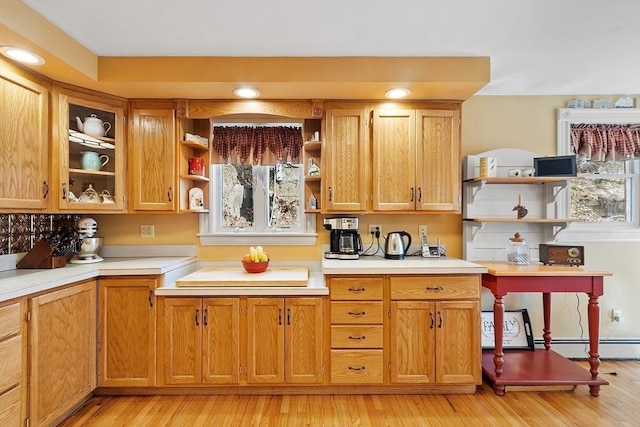 kitchen featuring open shelves, light wood-type flooring, and light countertops