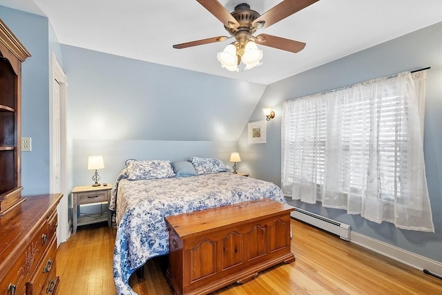 bedroom with baseboards, light wood-type flooring, lofted ceiling, and a baseboard radiator