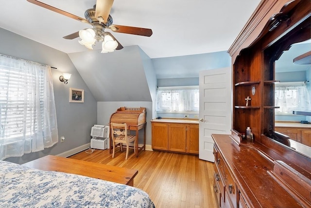 bedroom with vaulted ceiling, multiple windows, light wood-style floors, and baseboards