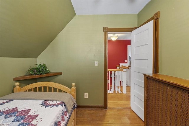 bedroom featuring lofted ceiling and wood finished floors