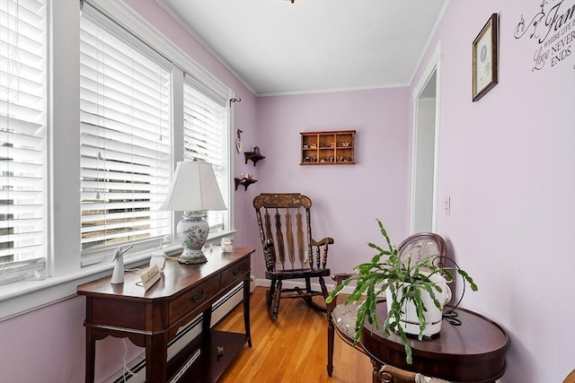 sitting room with baseboards, light wood-style flooring, and ornamental molding