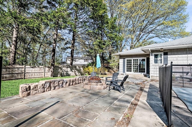 view of patio featuring an outdoor fire pit and fence