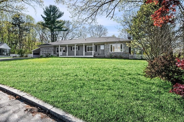 view of front facade with an attached carport, stone siding, and a front yard