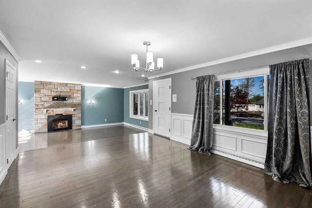 unfurnished living room featuring a fireplace, a chandelier, ornamental molding, and a baseboard radiator